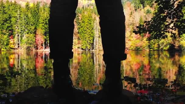 在风景秀丽的湖畔紧贴女性腿和靴子的低角度轮廓 秋天的自然是户外 自然装束及秋季时尚概念 — 图库视频影像