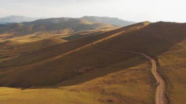 Hava teklifleri Ermenistan 'ın manzaralı kırsal kesimlerinde bisikletçiyi gösteriyor bisiklet doğada geziyor parlak gökyüzü arka planına sahip ılık yaz manzarasında