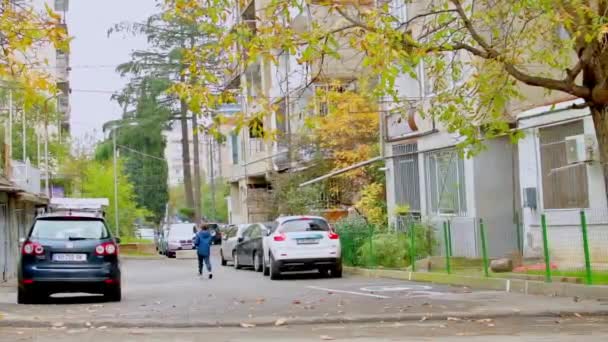 2021年10月30日 在佐治亚州第比利斯 男孩在Saburtalo街区被汽车包围 走在房子旁 Kercasus概念中的生活方式 — 图库视频影像
