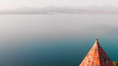 Üst kilise kubbesindeki manzaralı göl manzaralı altın haçı kapatın. Sevanavank Ermenistan Kilisesi