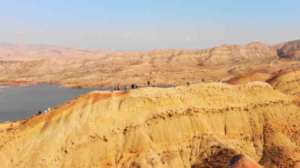 在具有水库背景的Mravaltskaro 空中观光客漫步在色彩斑斓的彩虹沙漠峡谷中 感受着独特的质感 — 图库视频影像