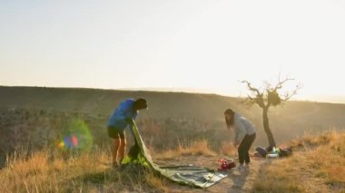 Statik zaman atlamalı çift, tatillerde doğa manzaralı bir yere çadır kuruyor. Birlikte yaşam tarzı seyahat ve görev konsepti