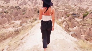 Genç çekici gezgin model kadın, Türkiye 'de turistik tatil gezilerinde jeolojik kireçtaşı oluşumlarında yavaş çekimde aşağı iniyor. Kaygısız mutlu kadın gezgin.