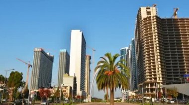 Dinamik hızlandırılmış Batumi şehir panoramasını trafikte arabalar ve güneşli bir günde vinçleri olan emlak şantiyeleriyle yakınlaştırın. İnşaat işi gayrimenkul geliştirme kavramı