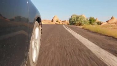 Kapadokya 'nın terk edilmiş hindi bölgesinde asfalt yolda dönen çarkın yan görüntüsü. Off road ve mekanik konsepti