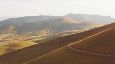 Aerial view cyclist in scenic Armenia countryside mountains bicycle touring outdoors in nature in warm summer landscape with bright sky background