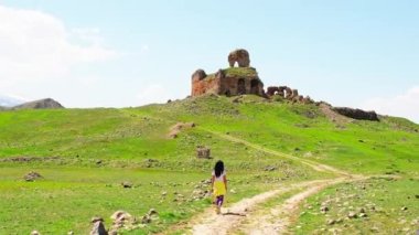 Female tourist woman walk to Bana cathedral ruins-famous georgian orthodox historical monument