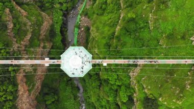 Dashbashi, Gürcistan - 19 Haziran 2022: Gürcistan kırsalındaki manzaralı dashbashi vadisinde cam köprü üzerindeki elmas şekilli platformun üzerinde uçmak. Kafkasya 'daki vadi üzerindeki ünlü modern köprü