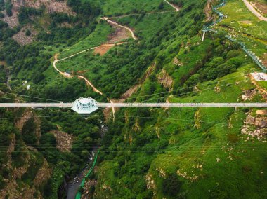 Dashbashi, Gürcistan - 19 Haziran 2022: Gürcistan kırsalındaki manzaralı dashbashi vadisinde cam köprü üzerindeki elmas şekilli platformun üzerinde uçmak. Kafkasya 'daki vadi üzerindeki ünlü modern köprü