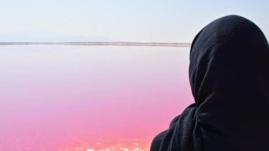 Maharlu pembe tuz gölü kıyısında beyaz kadın turist duruyor. İran 'ın Şiraz' a seyahat hedefi
