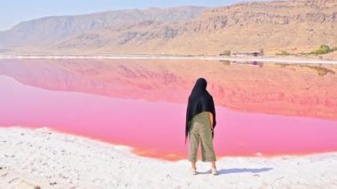 Maharlu pembe tuz gölü kıyısında beyaz kadın turist duruyor. İran 'ın Şiraz' a seyahat hedefi