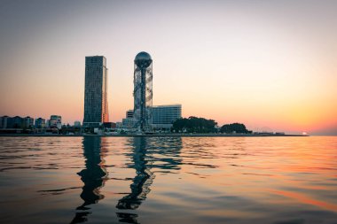 Panoramic view of Iveria beach and Batumi landmarks with sunrise in the background. Travel destination in Georgia republic.