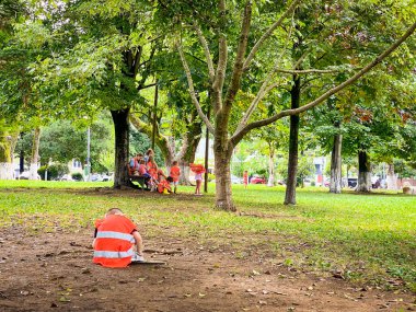 Batumi, Georgia - 8th august, 2022: teacher spend time with playing kids in public park. Education and study childhood in big cities concept