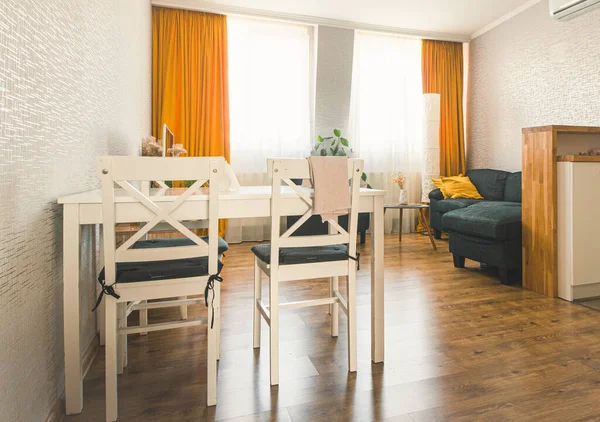 Cozy studio apartment kitchen with table sofa and bright interior autumn color palette