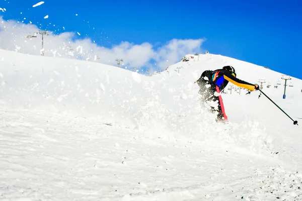 アルプスのスキー場のダイナミックな写真 柔らかい雪の中で女性スキーヤー アクティブな冬の休日 晴れた日にスキーダウンヒル 新鮮な雪の渦とトラックに乗ってスキー — ストック写真