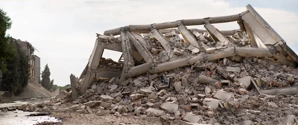 Vista panorámica del edificio industrial de varios niveles de hormigón colapsado. Escena desastrosa llena de escombros, polvo y casa dañada. — Foto de Stock