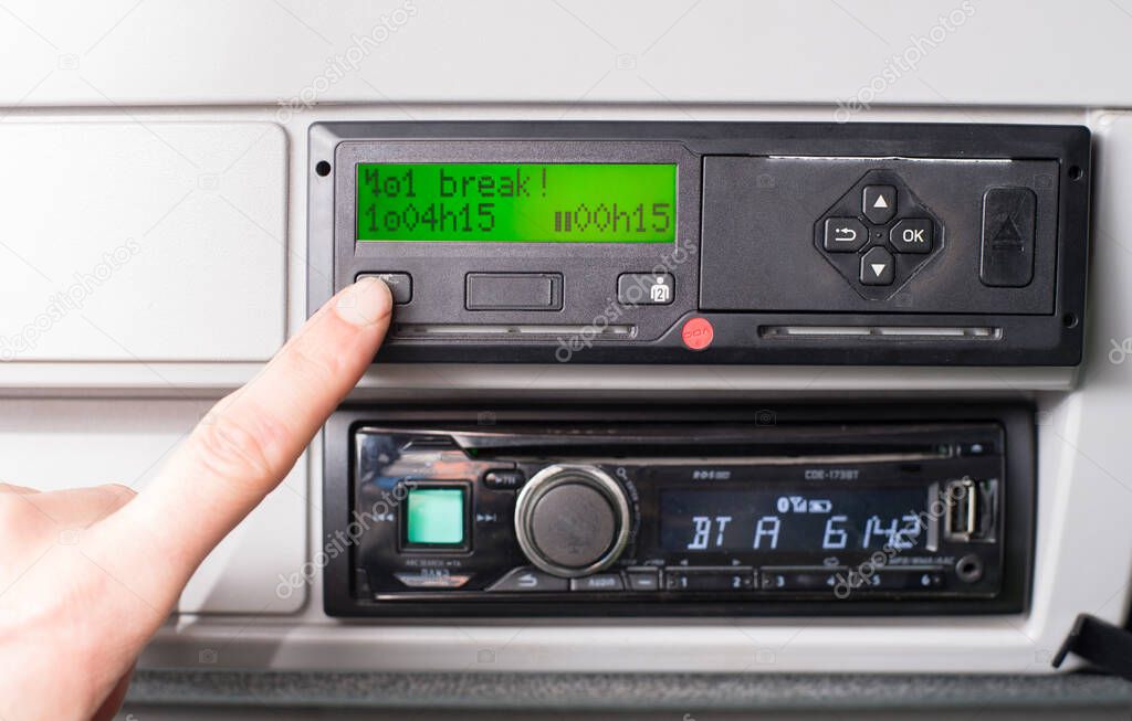 Close up of a driver and tachograph with 15 minutes of driving left warning on display