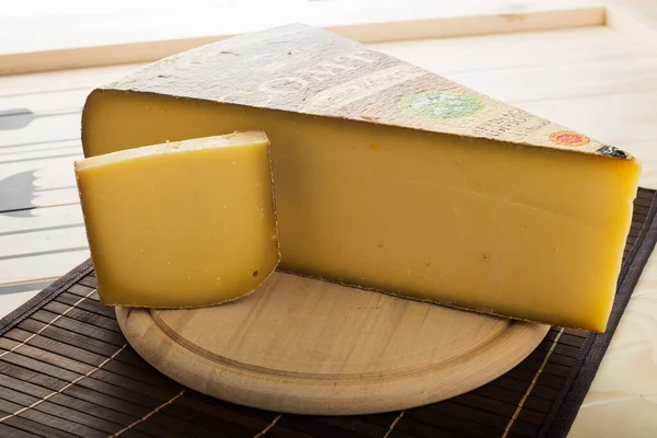 Оломоуц Чехия 21 января 2015 Comte AOP Reserve cheese disc on a wooden plate — стоковое фото