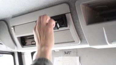 Takografta bir rulo kağıdı değiştiren bir sürücünün fotoğrafı. Bir kamyonun dijital takografında kağıt rulosu değiştirme