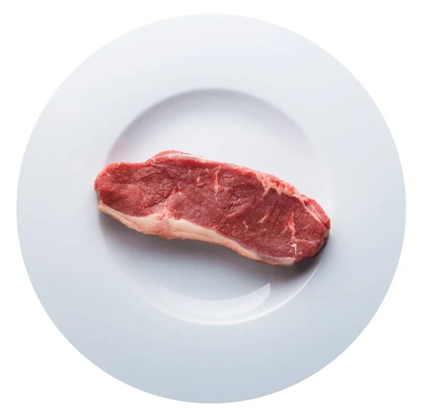 Pezzo unico di carne cruda su un piatto bianco isolato su bianco. Vista aerea dall'alto — Foto Stock