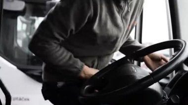 Kamyon şoförü kamyonun direksiyonuna geçiyor..