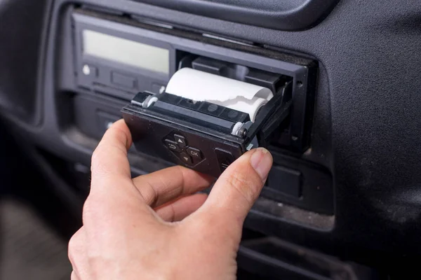 Digital tachograph with an open printer and visible roll of paper. Paper roll Replacement in a truck digital tachograph.