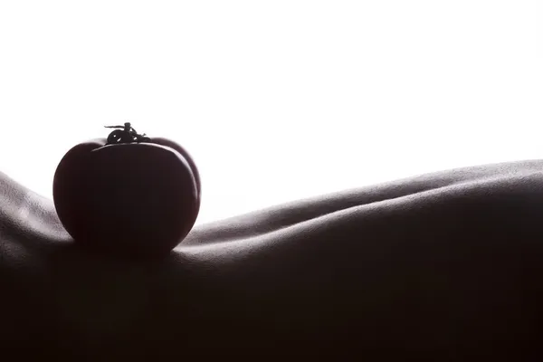 Tomato on woman skin — Stock Photo, Image