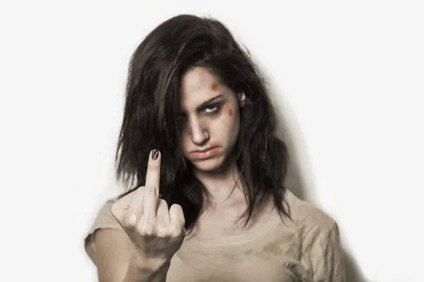 Beaten up girl showing middle finger — Stock Photo, Image