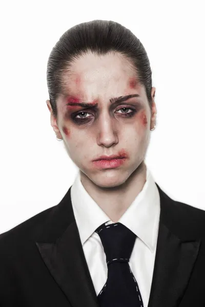 Beaten up girl with sad expression wearing coat and tie — Stock Photo, Image