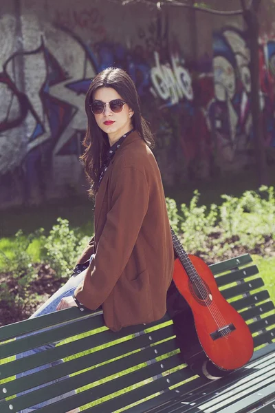 Fille assise sur un banc et regardant — Photo