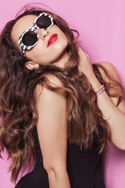 Woman with beautiful hair wearing sunglasses and posing — Stock Photo, Image