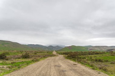 Bulutlu hava dağlık bir bölgede toprak yol