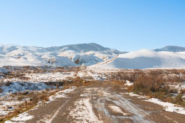 Dirt road to mountains in early spring season