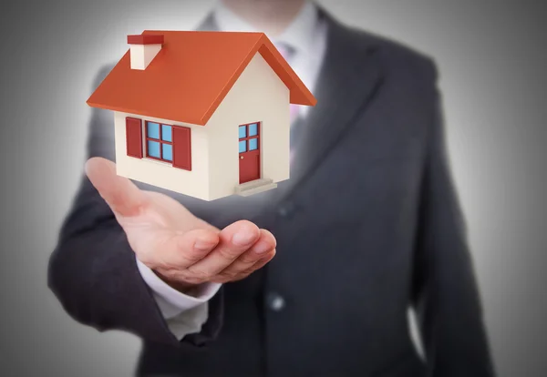 Businessman showing a little house — Stock Photo, Image
