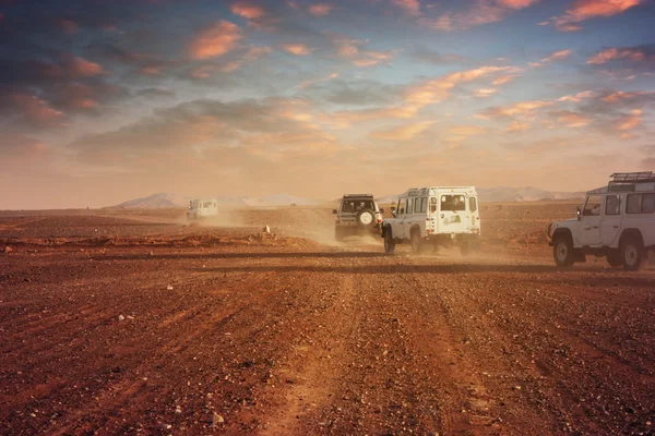 Carros no deserto ao pôr do sol — Fotografia de Stock