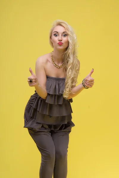 Mujer de pie sobre fondo amarillo — Foto de Stock