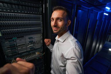 Sakallı adam teknisyeni sunucu çiftliğinde ekipmanla çalışıyor.