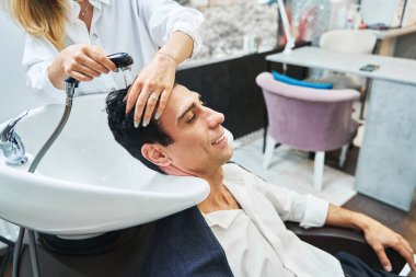 Müşteri güzellik salonu lavabosunda saç yıkamayı seviyor.