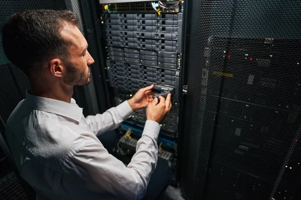 Красивый кавказский системный администратор контролирует операционную серверную в помещении — стоковое фото