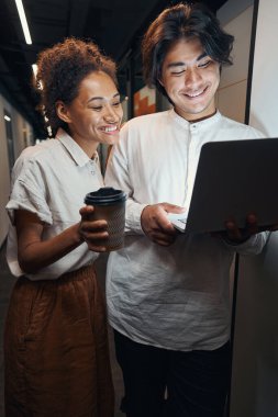 Çalışanlar mutlulukla dizüstü bilgisayara bakıyor