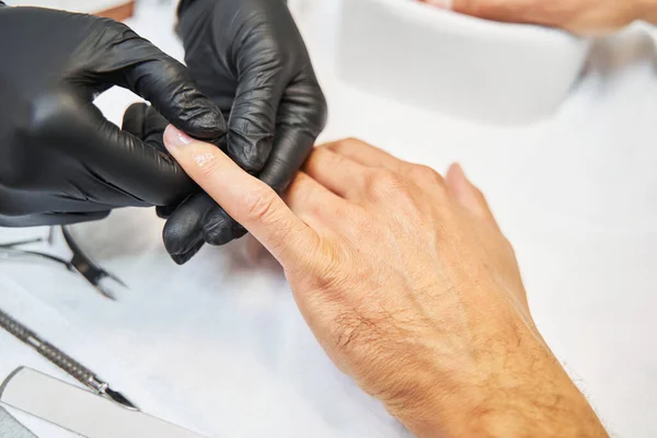 Manucure maître étalage huile de peau sur le doigt — Photo