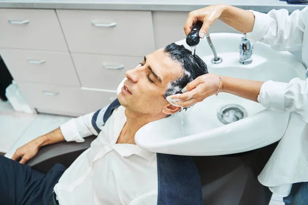 Barber ψεκασμού νερού στα μαλλιά της χαλαρής πελάτισσας — Φωτογραφία Αρχείου