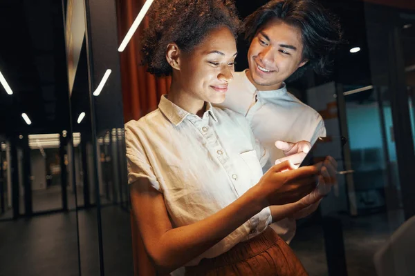 Sonriente hombre hablando de noticias con collegue en corredor —  Fotos de Stock