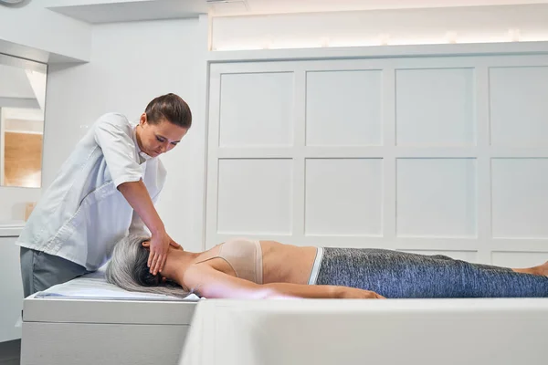 Professional medical worker doing massage on neck — Stock Photo, Image
