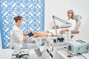 Kaba deriyi kestikten sonra ayaklara masaj yapan sevimli podolojist.