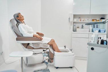 Rahatlamış olgun müşteri güzellik salonunun tadını çıkarıyor.