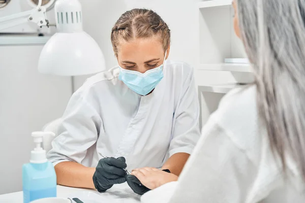 Vrolijke stylist praten met haar vrouwelijke cliënt — Stockfoto