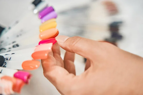 Female person pointing at bright nail polish — Stock Photo, Image