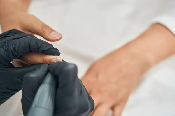 Закрыть мастера красоты с помощью электрического дрилла для ногтей — стоковое фото