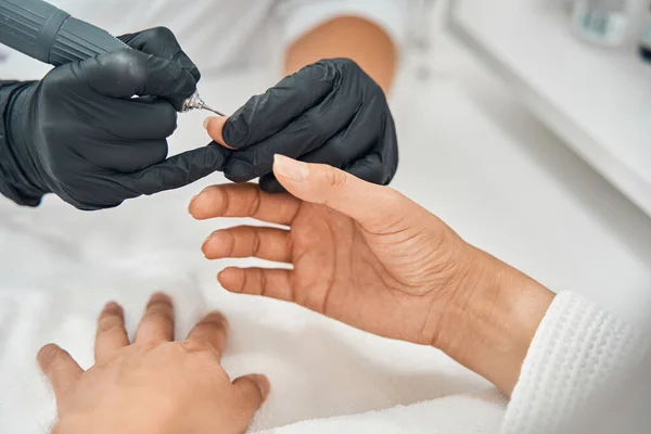 Foto enfocada en esteticista haciendo manicura profesional —  Fotos de Stock